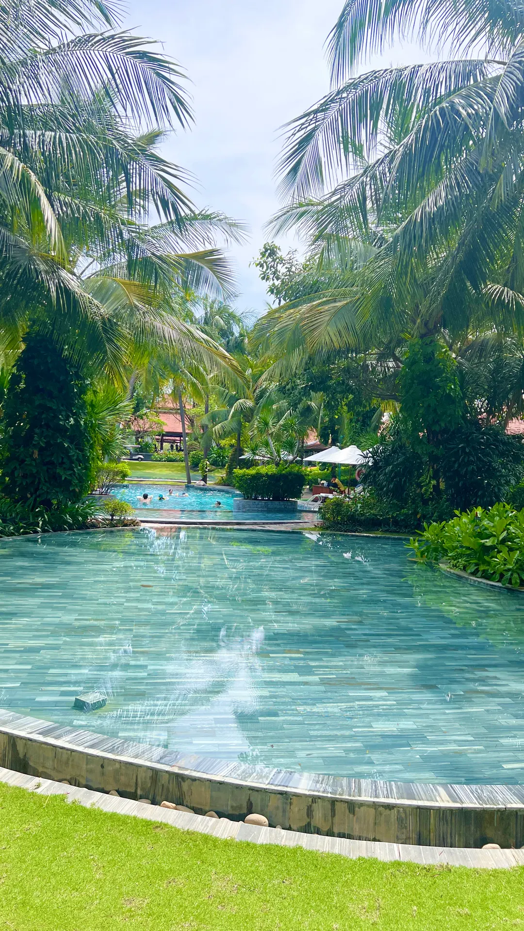 Lush green lawn and pool at The Anam