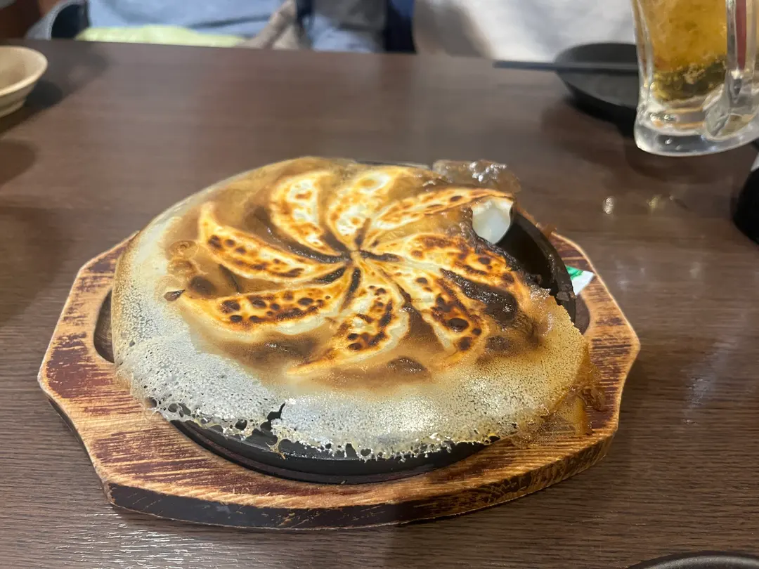 熱々の鉄鍋餃子を取り分ける様子