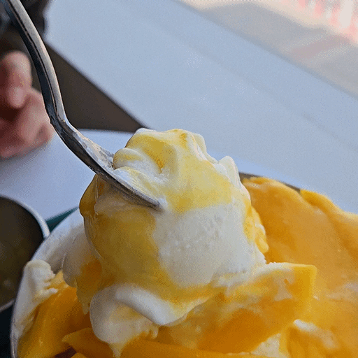Pouring sweet mango syrup over bingsu