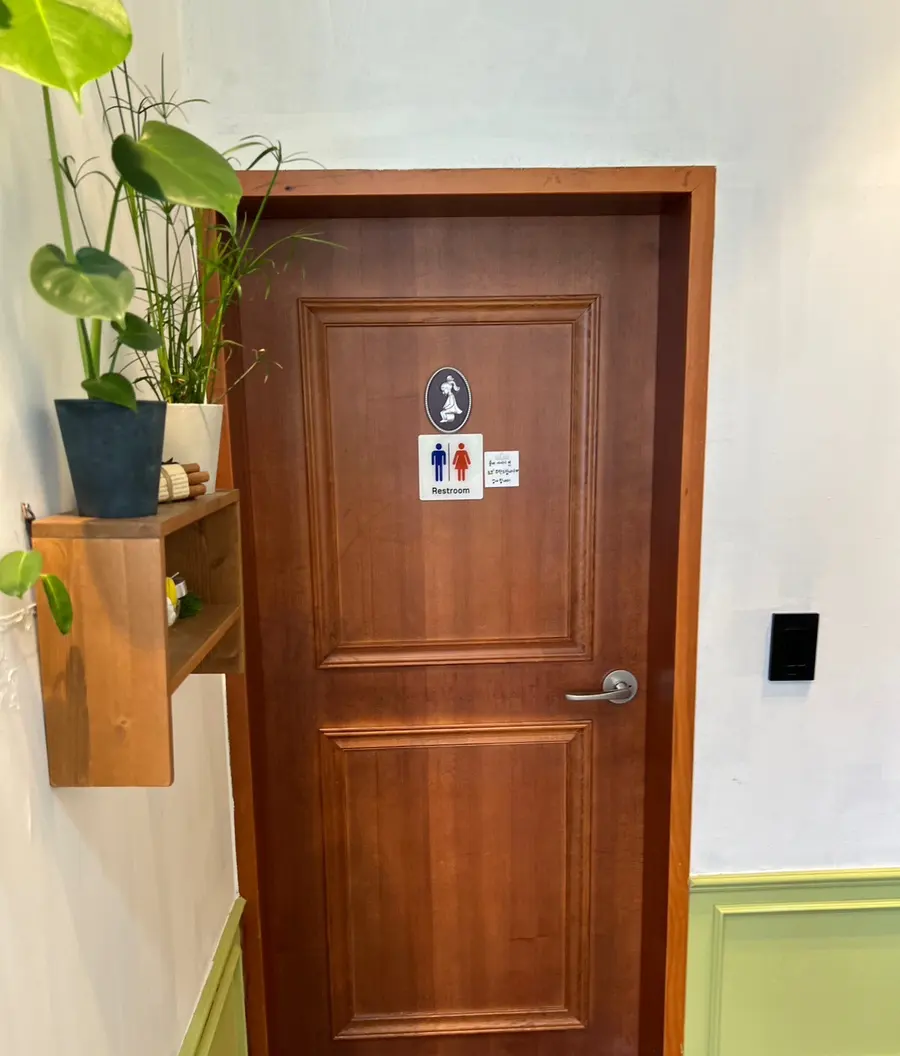 Restroom entrance with green plants