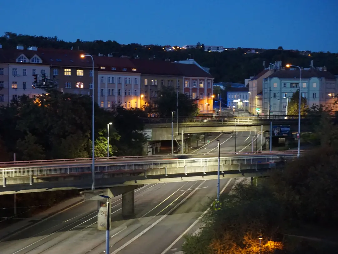 A lone traveler enjoying the illuminated Charles Bridge in Prague at night, illustrating safe tourist areas.