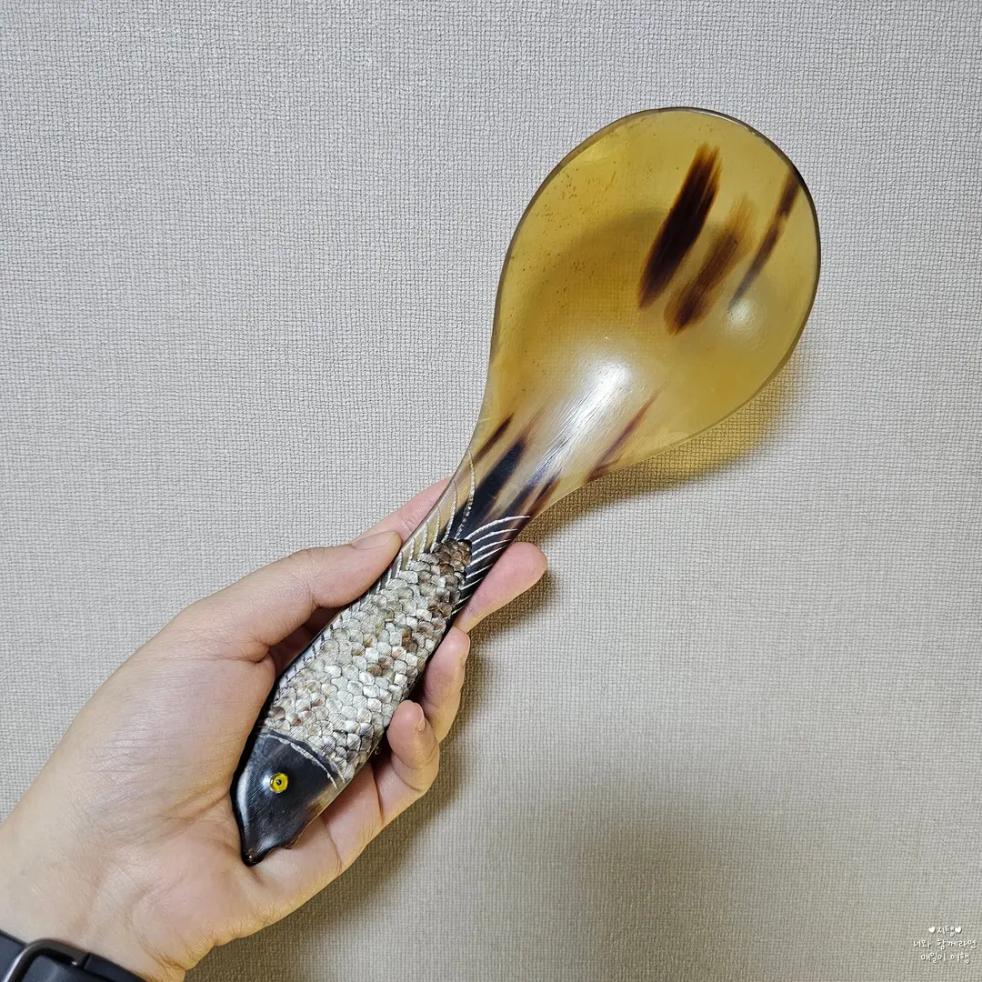 The handle has a delicate fish scale-like texture.