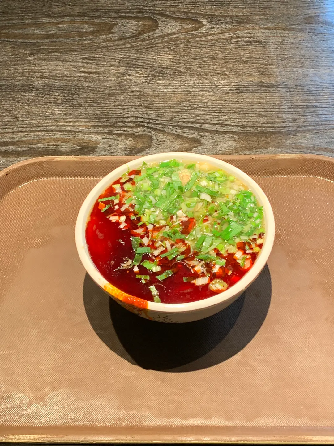 Close-up of Lanzhou beef noodles with chili oil and scallions