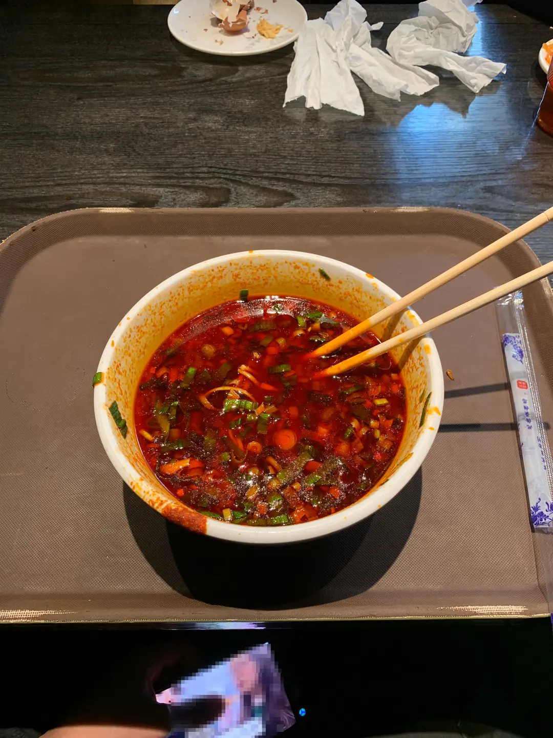 A bowl of Lanzhou beef noodles, showing the vibrant chili oil
