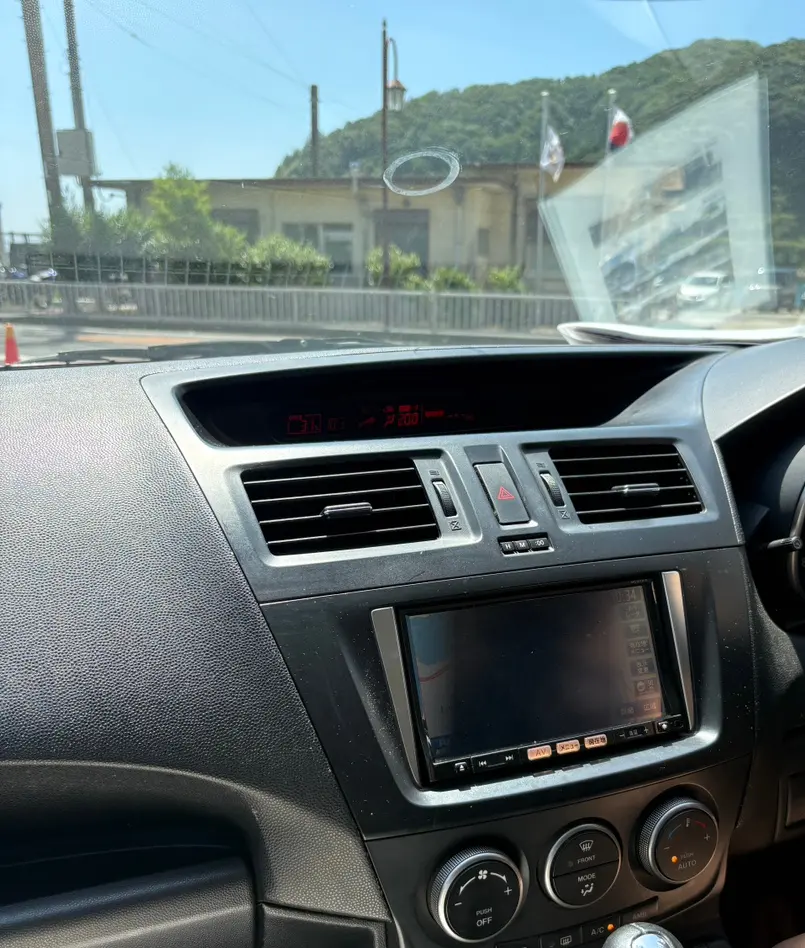 A smartphone mounted on a car dashboard, displaying a navigation app.