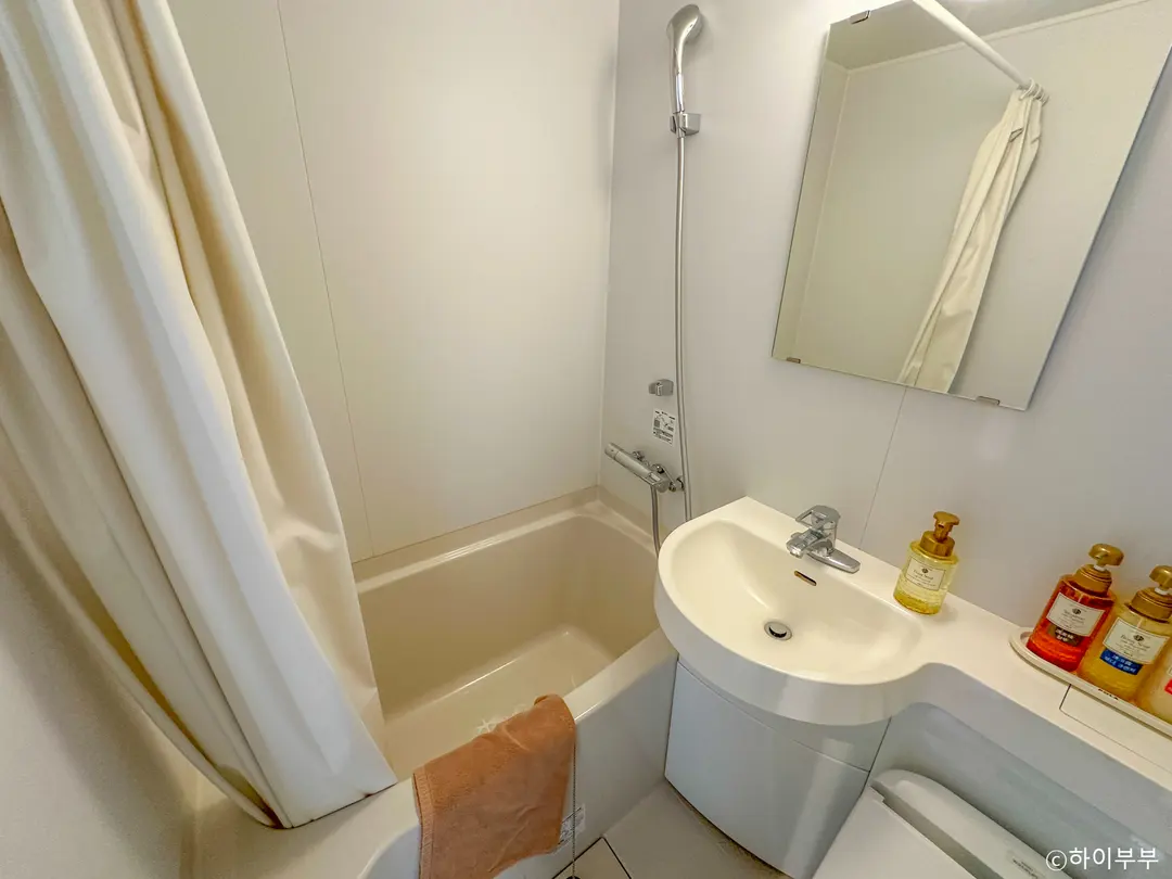 Compact hotel bathroom with toilet and sink