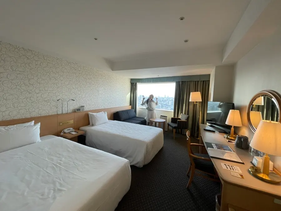 Hotel room with two beds, sofa, and table