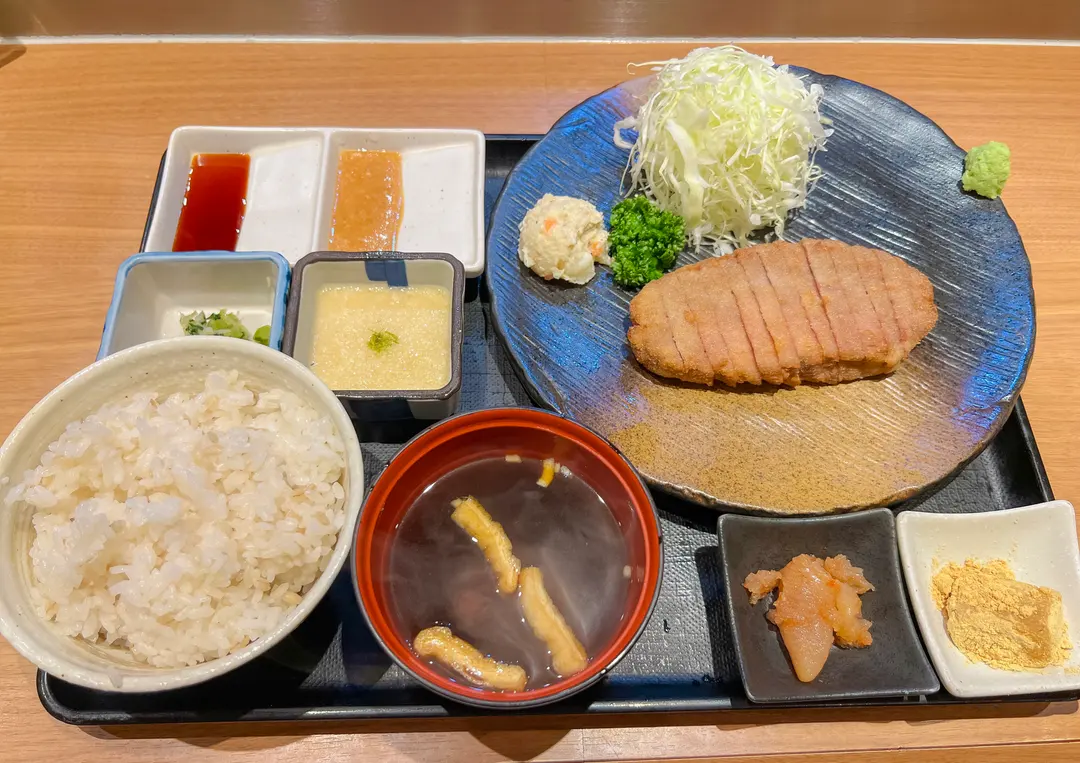 A personal grilling stone at Motomura Gyukatsu with slices of rare gyukatsu ready to be cooked.