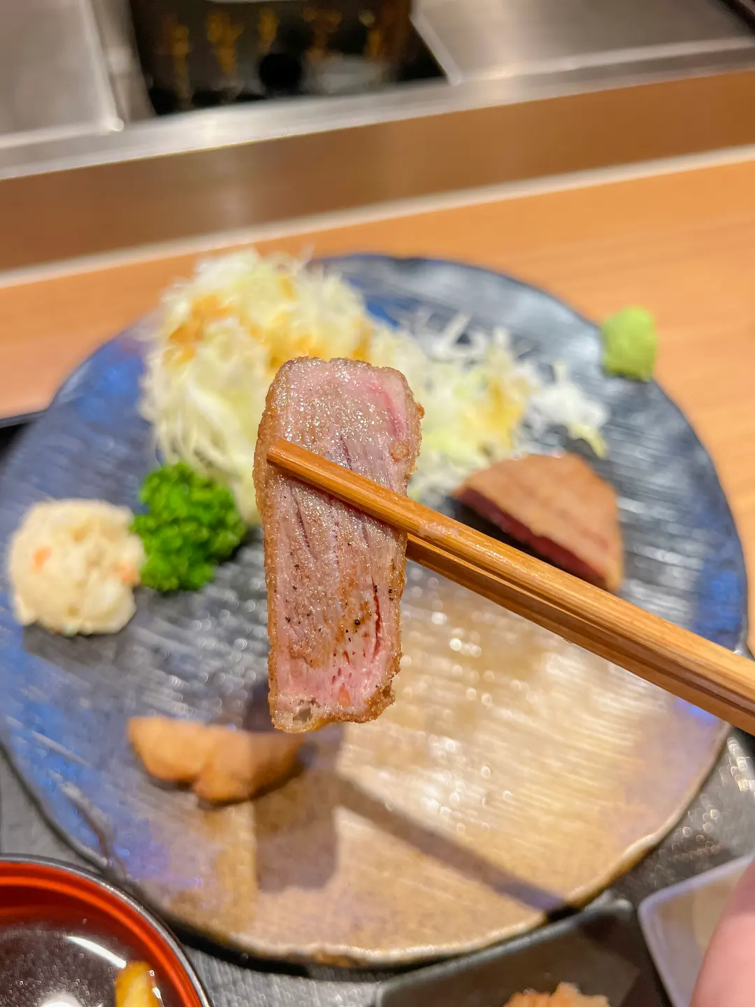 Close-up of a cooked slice of gyukatsu, showing its tender texture and juicy interior.