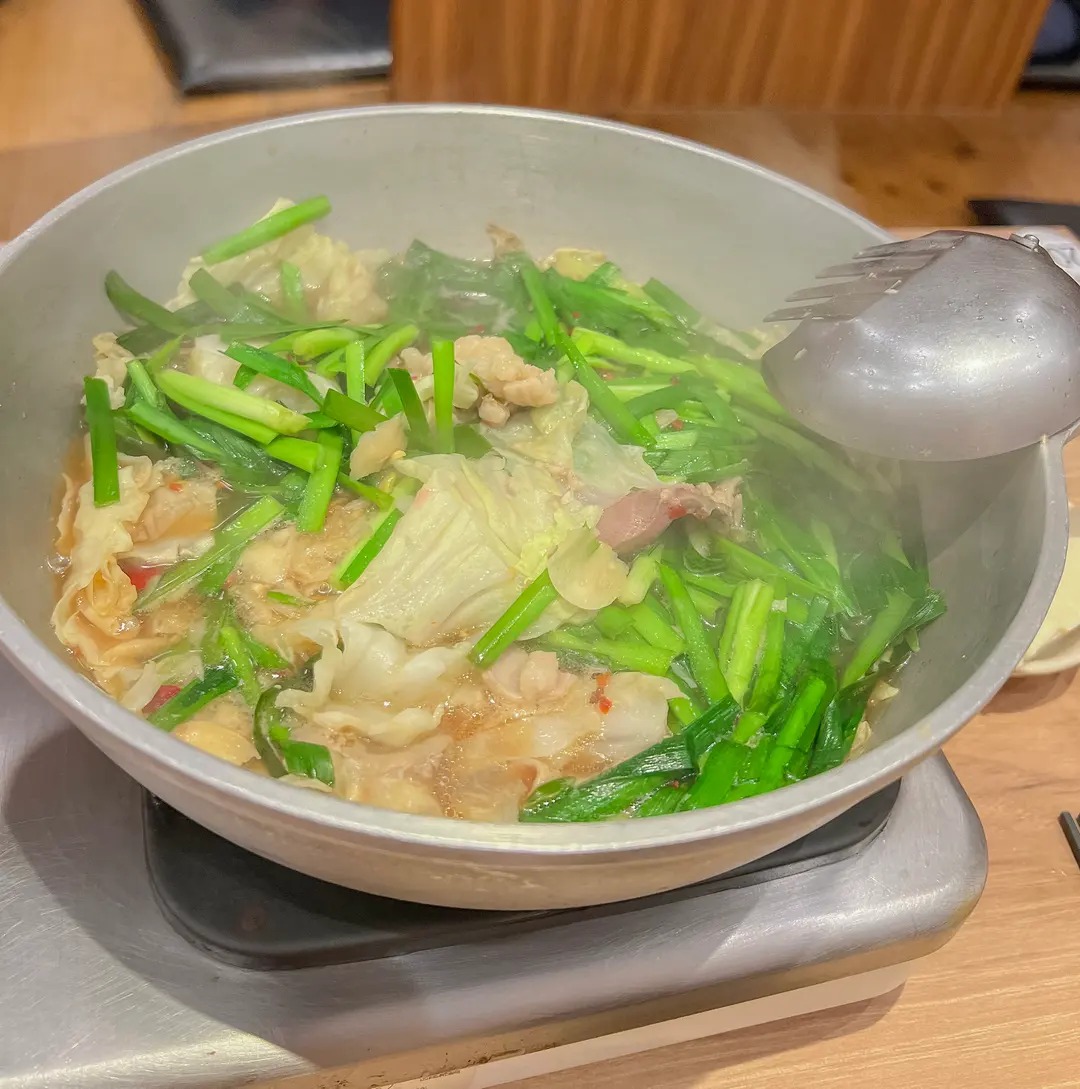 A serving of Motsunabe in a bowl, with a clear view of the rich broth and tender offal.