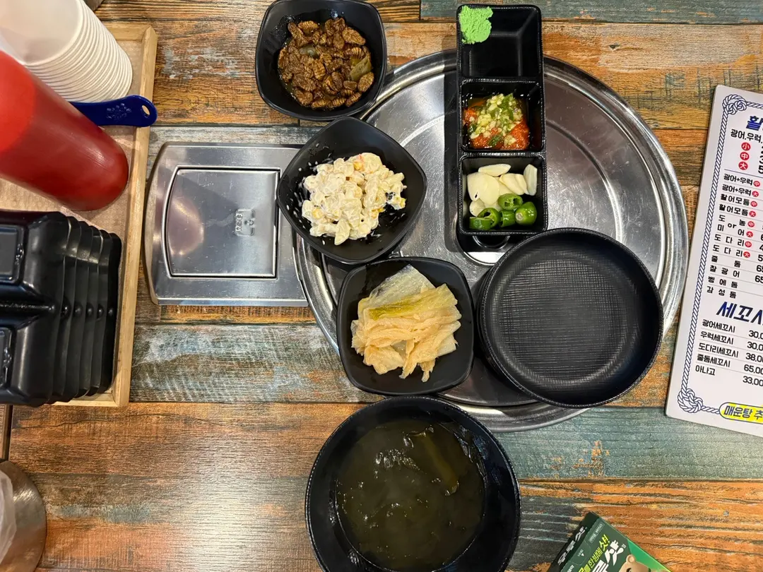 Variety of Korean side dishes including beondegi and white kimchi
