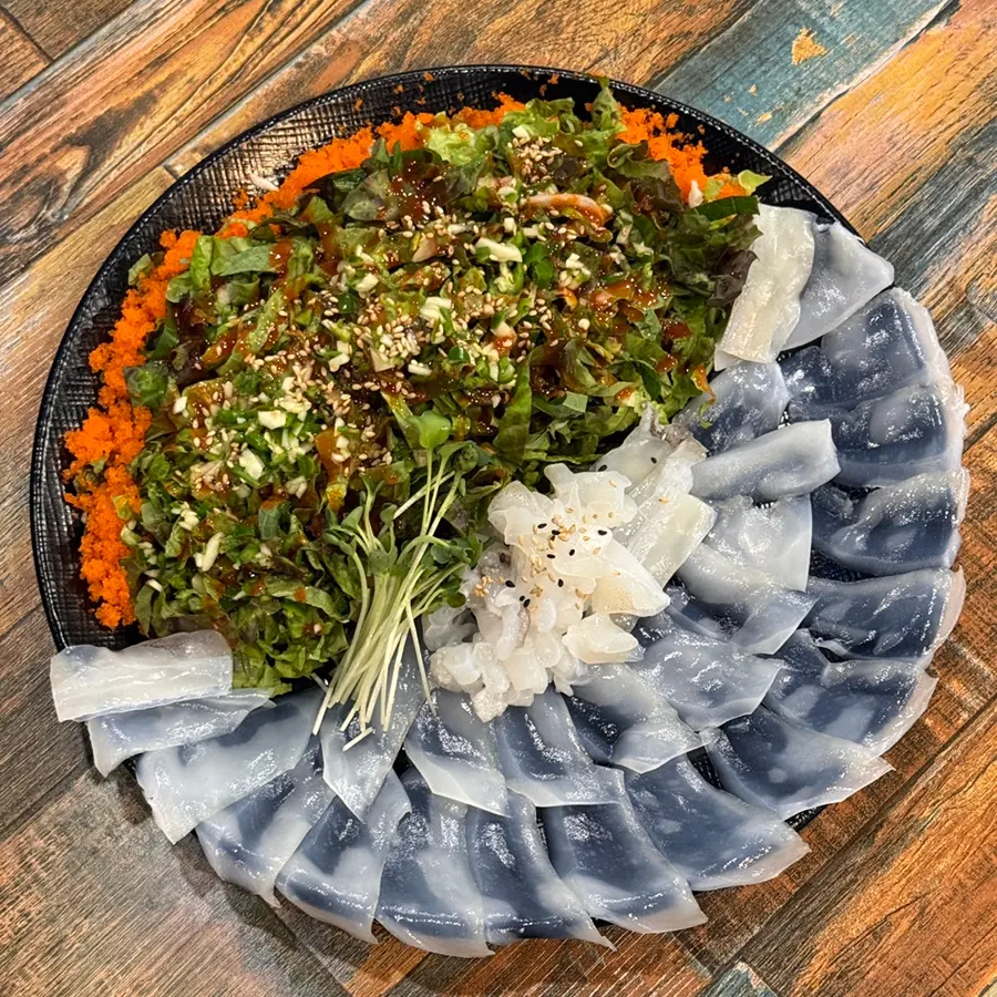Beautifully plated sliced cuttlefish sashimi with vegetable mix
