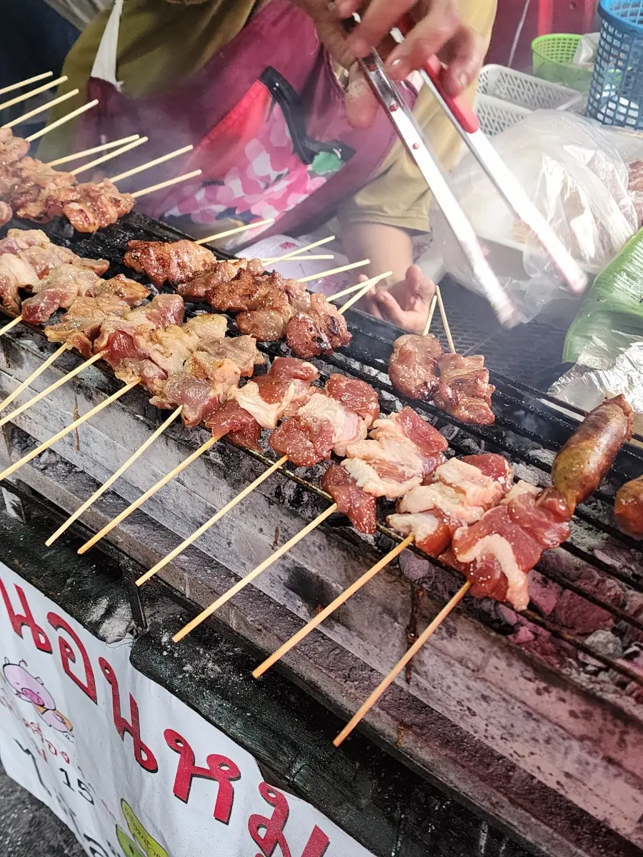 Mu Ping skewers and sticky rice being prepared