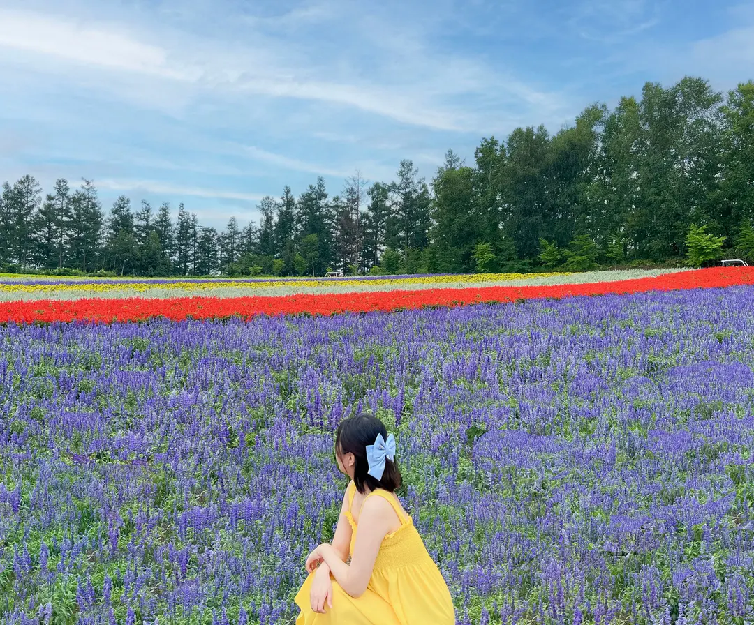 A traveler wearing a light summer dress, enjoying a sunny day outdoors.