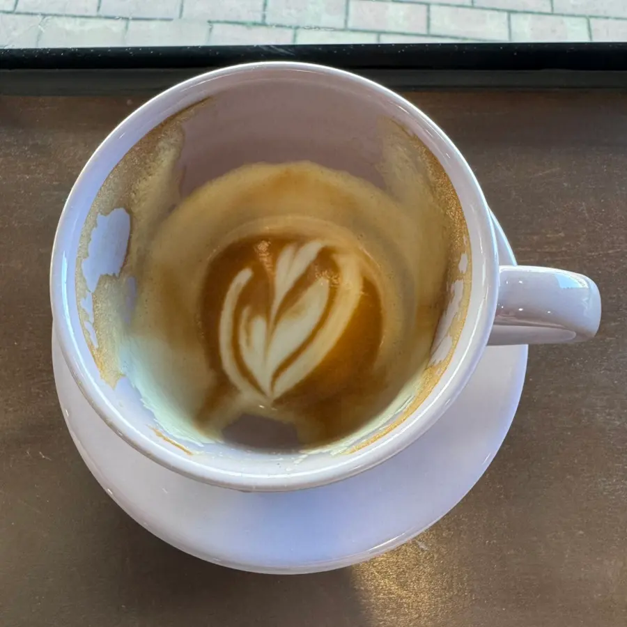 Latte art still visible in almost empty cup