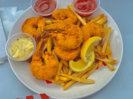 A lobster meal with corn on the cob.