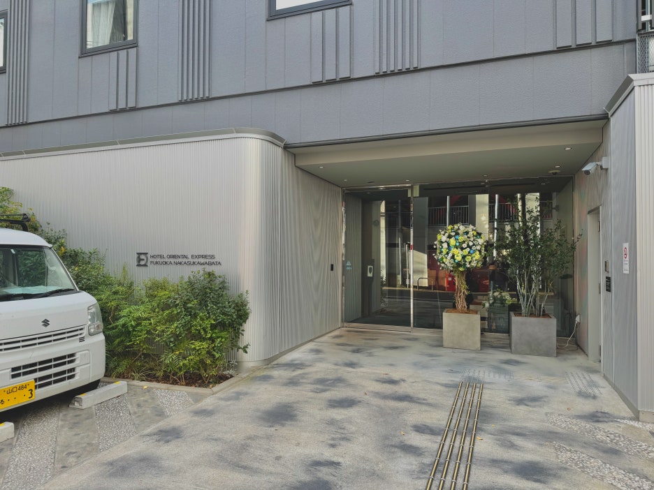 The hotel entrance with automatic doors and accessibility features like braille blocks.
