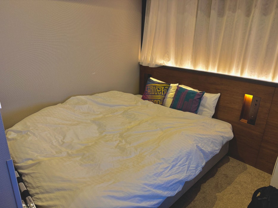 A clean and cozy hotel room with a double bed and modern decor.