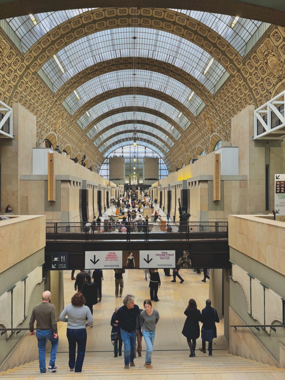 Looking down the main aisle of the Musée d'Orsay, filled with sculptures and visitors.
