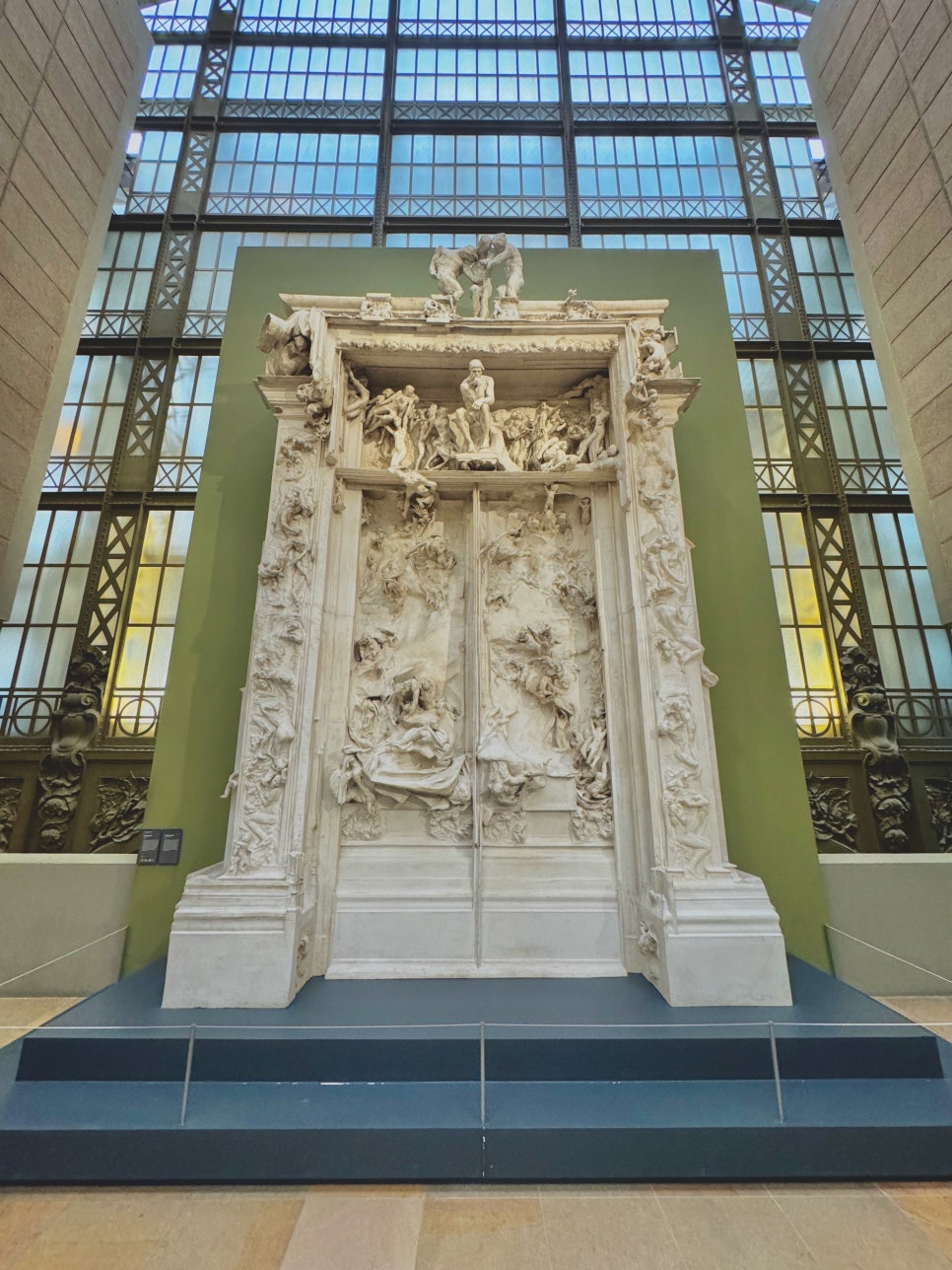 A crowd of visitors admiring paintings in one of the Orsay's sunlit galleries.