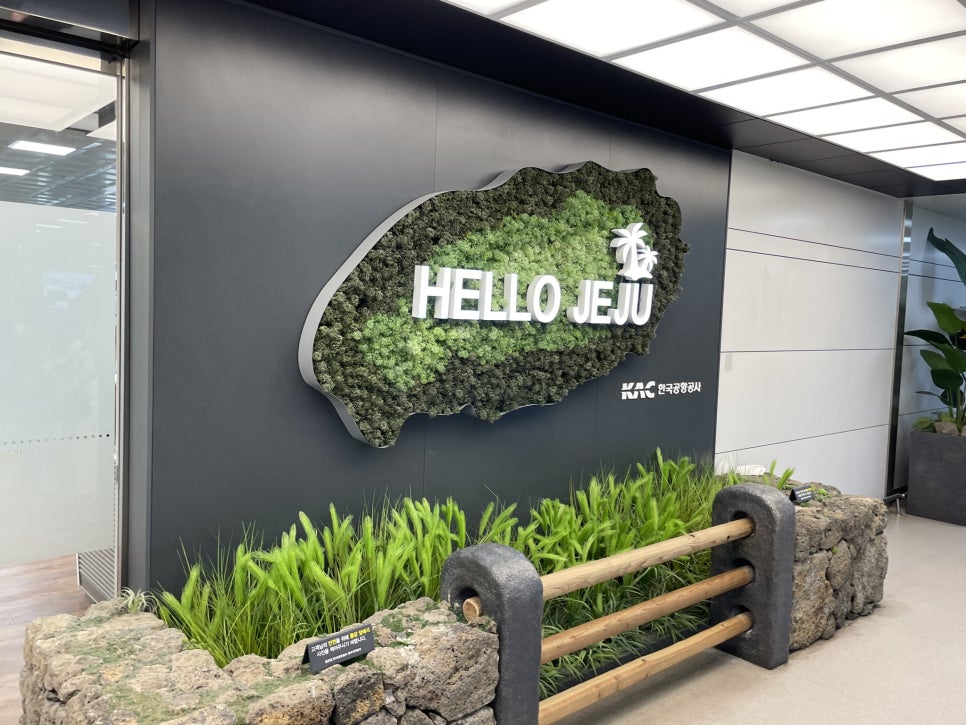 A scenic coastal road on Jeju Island with a blue bus driving on it