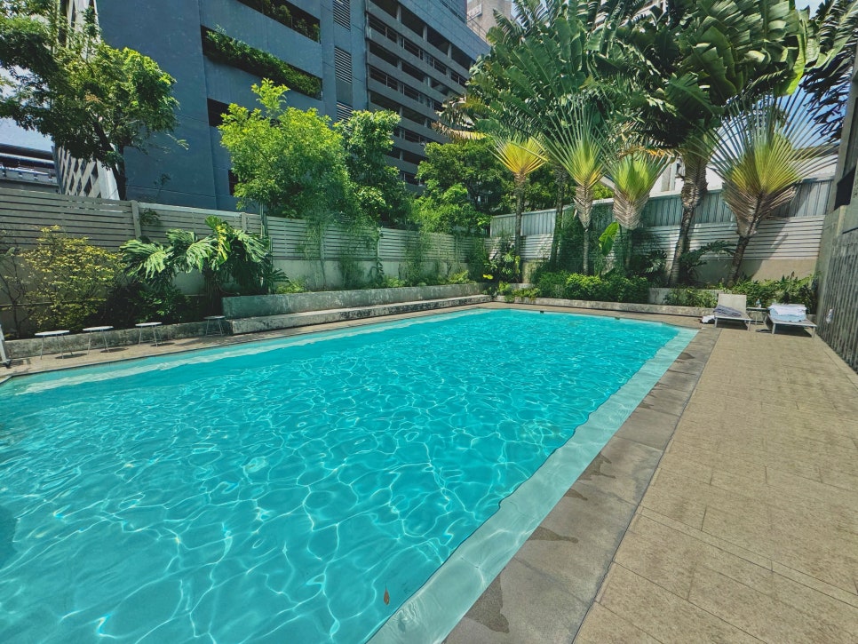 The serene outdoor swimming pool area with sun loungers